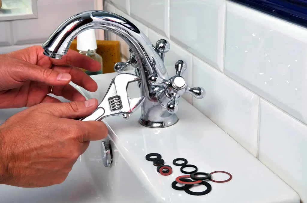 Plumber performing maintenance on a bathroom faucet in Naples