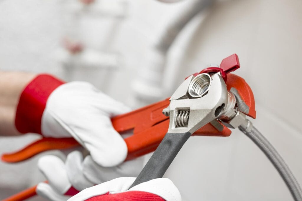 Plumber holding pipe wrenches for an emergency repair in Naples