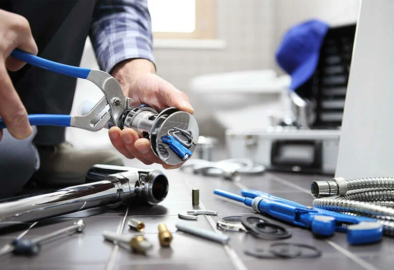 Technician repairing a plumbing fixture with professional tools in Naples