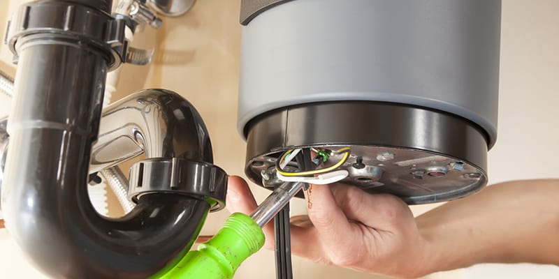 Technician repairing the heating element of a water heater in Naples
