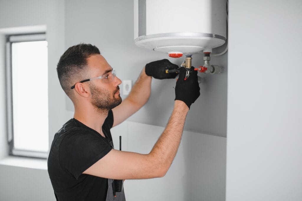Technician performing water heater maintenance in Naples