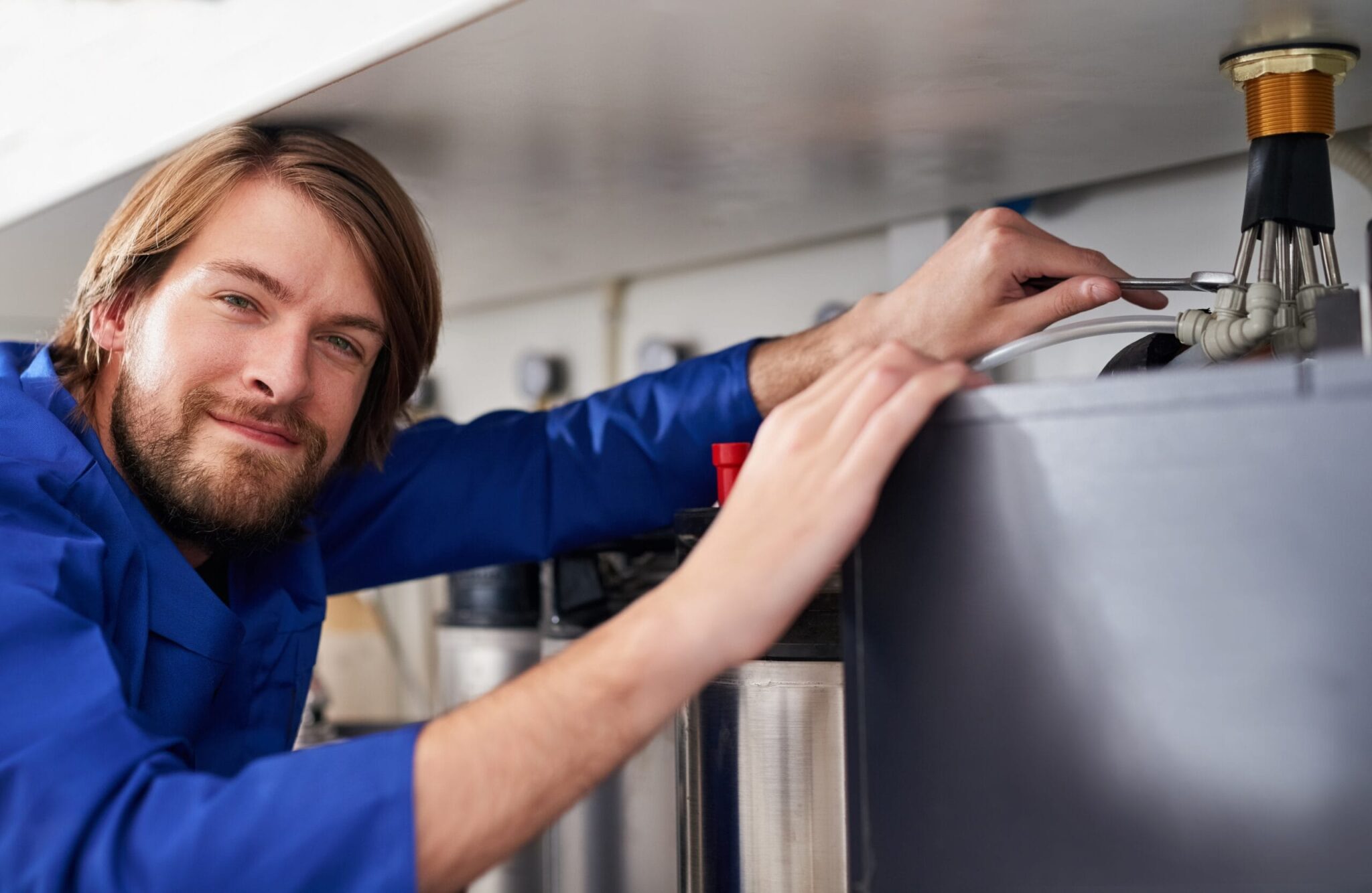 Technician servicing a residential water heater tank in Naples