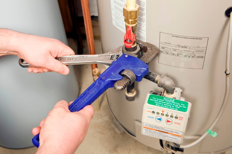Plumber repairing a water heater valve in Naples